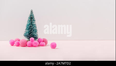 Modello in miniatura inverno pino con neve sfere rosa decorazione, con atmosfera festa di Natale. Piccolo giocattolo nevoso albero di Natale Concetto di nuovo Y Foto Stock