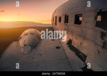 Danneggiato aereo sulla montagna contro il tramonto. Solheimasandur Islanda Foto Stock