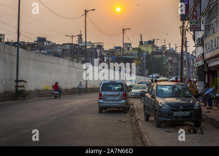 Nella tarda mattinata di sole attraverso inquinato cielo di New Delhi street Foto Stock