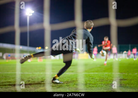 Il portiere prendere la palla quando sulla difensiva obiettivo durante una partita di calcio Foto Stock