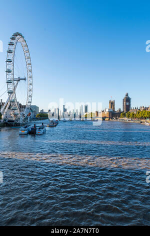 Il London Eye e le case del Parlamento sul Tamigi Foto Stock