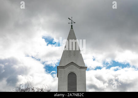 Vecchia chiesa steeple con una banderuola contro un cielo tempestoso, nella parte orientale della Long Island, NY Foto Stock