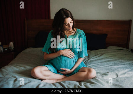 Donna incinta a letto Foto Stock