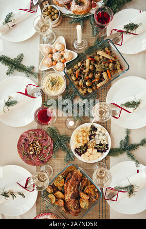 Vista superiore sullo sfondo di un bellissimo tavolo per la cena decorata con rami di abete impostato per il banchetto di Natale, spazio di copia Foto Stock
