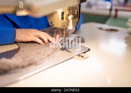 I dettagli di cucitura di pelliccia e cuoio. Produzione di calzature. Foto Stock