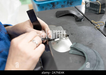 Abbassando i bordi delle parti. Produzione di calzature. Foto Stock