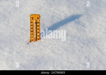 Termometro in legno nella neve con temperature di congelamento. Foto Stock