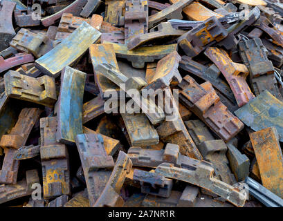Pila di usato e rusty treno pattini freno in un magazzino Foto Stock