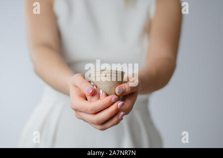 Close-up di donna mani tenendo un vuoto bicchiere di carta. Foto Stock