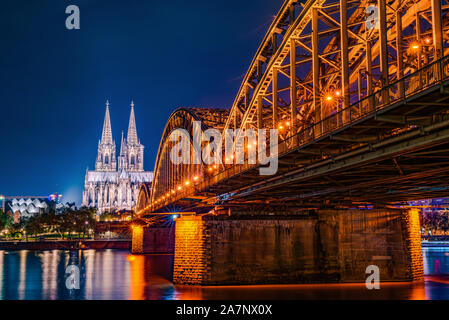 Panorama della città di Colonia di notte con la cattedrale di Colonia, ponte di Hohenzollern e il fiume Reno Foto Stock