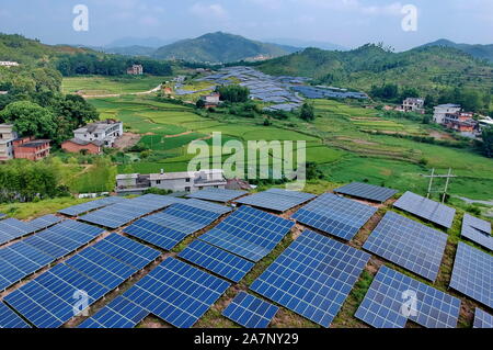 Array di pannelli solari sono installati presso le terre incolte su una collina nel villaggio Huangsha, Zhuangkou town, Huichang county, Ganzhou città, Oriente Cina Foto Stock