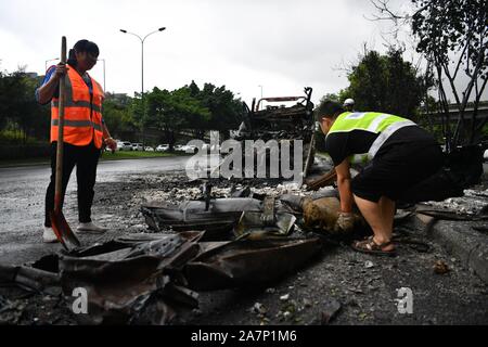 Gli operatori sanitari puliti in corrispondenza della zona dove la combustione spontanea di un auto è accaduto nella città di Chengdu, a sud-ovest della Cina¯s nella provincia di Sichuan, 5 agosto Foto Stock