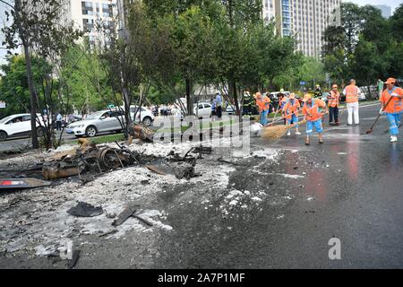 Gli operatori sanitari puliti in corrispondenza della zona dove la combustione spontanea di un auto è accaduto nella città di Chengdu, a sud-ovest della Cina¯s nella provincia di Sichuan, 5 agosto Foto Stock