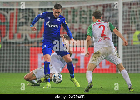 Augsburg, Germania. 3 Novembre, 2019. Bastian Oczipka (top, L) di Schalke 04 controlla il pallone durante un match della Bundesliga tra FC Augsburg e FC Schalke 04 ad Augsburg, in Germania, su nov. 3, 2019. Credito: Philippe Ruiz/Xinhua/Alamy Live News Foto Stock