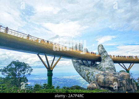 Turisti visitano il Golden Bridge detenute fino a mano statue circondato da nebbia e nuvole al Bana Hills di Da Nang, Vietnam, 19 agosto 2019. Bana H Foto Stock