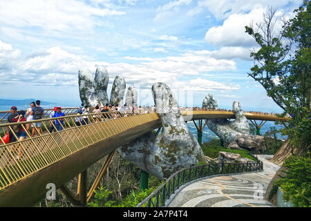 Turisti visitano il Golden Bridge detenute fino a mano statue circondato da nebbia e nuvole al Bana Hills di Da Nang, Vietnam, 19 agosto 2019. Bana H Foto Stock