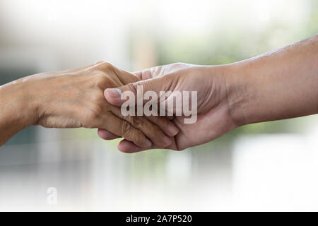 La gente vecchia donna e giovane azienda a mano disabilitata camminando con assistenza Foto Stock