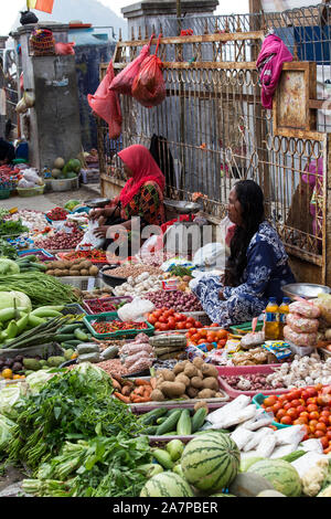 Labuanbajo, Indonesia - Agosto 17, 2015: gruppo non identificato di donne che indossano hijab e guarnizioni tradizionali vendono frutta tropicale in strada Foto Stock