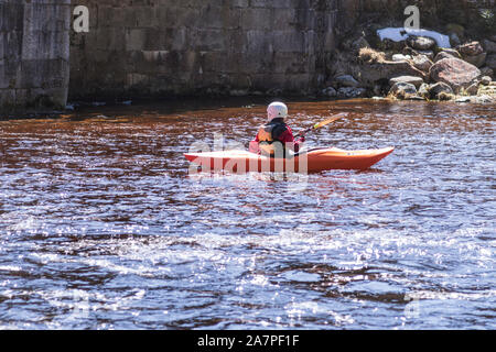 Donna sul kayak.Donna sulla banca del fiume sono in appoggio versando acqua da imbarcazioni che trasportano il kayak sul fiume.una vista dello sport è il kayak. Foto Stock