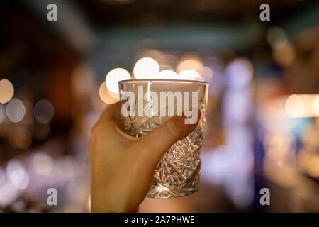 Immagine ravvicinata di una mano che tiene un Glencairn single malt whisky in vetro. Foto Stock