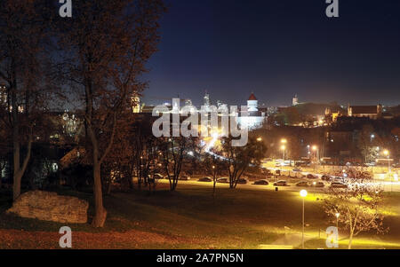 Vilnius city illuminata di notte con Gediminas tower, tre croci e la chiesa della Santa Madre di Dio dal bastione hill Foto Stock