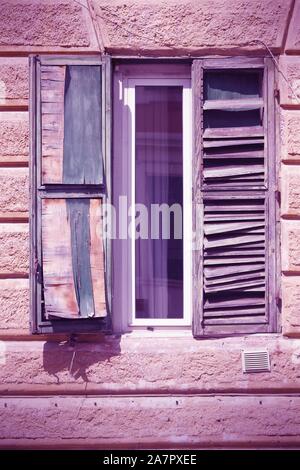 Roma, Italia - caratteristica architettonica nel quartiere di Trastevere, vecchia finestra. Croce di colore trasformati in stile retrò - immagine filtrata di tono. Foto Stock