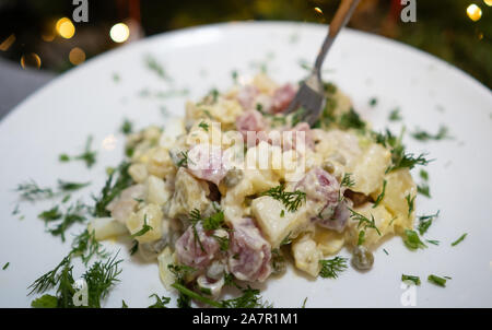 Tradizionale russo Insalata di Natale Olivier su una piastra bianca. Foto Stock