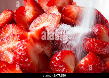 Rosso fragola tagliata in piccoli pezzi e con zucchero Foto Stock
