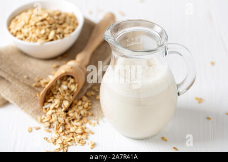 Latte di avena. Vegano sano non a base di latte da bere organico con fiocchi Foto Stock
