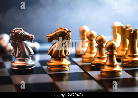 Cavallo di scacchi di fronte rappresentano insieme di negoziare un rivale o un nemico di business in una guerra commerciale gioco. Foto Stock