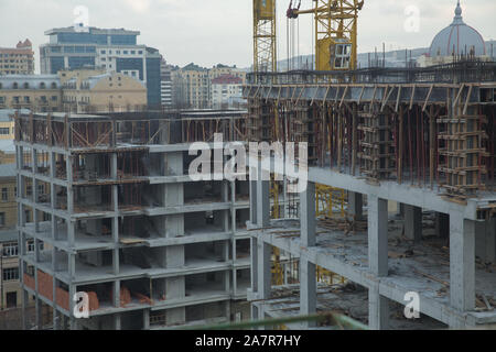 Grande sito di costruzione compresi più gru lavorando su un complesso di edifici. Lavorando su un sito di costruzione . Il nuovo edificio è in costruzione. Foto Stock