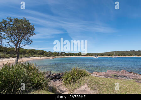 Guardando lungo la spiaggia Jibbon dall'estremità orientale indietro verso il villaggio di Bundeena nel sud di Sydney, Australia su una soleggiata giornata di primavera Foto Stock