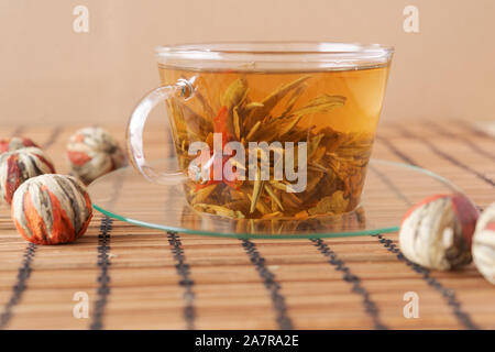 Tazza di tè verde con giglio rosso fiore Foto Stock