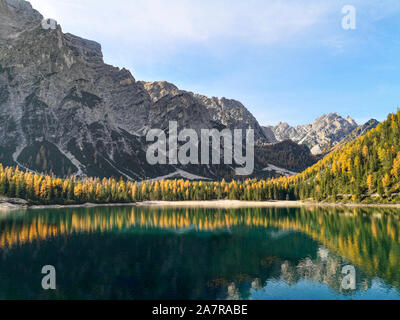 L'Italia, Trentino Alto Adige: paesaggio naturale del Lago di Braies con verdi alberi, il lago con la riflessione e la montagna con la neve Foto Stock