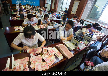 --FILE--Bank cancellieri conteggio (RMB) renminbi yuan banconote durante un contasoldi concorso di competenze nella città di Nantong, est cinese della provincia di Jiangsu, 19 Augu Foto Stock