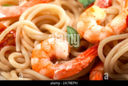 Pasta spaghetti con gamberi e pomodori secchi e basilico closeup. Pasto sano. Il cibo italiano. Foto Stock