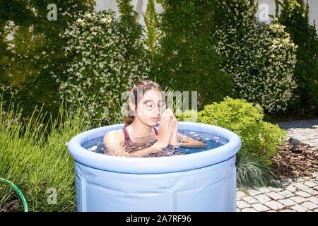 La donna in una piscina piena di ghiaccio, seguendo il Wim Hof metodo (WHM), una combinazione di frequente esposizione al freddo, tecniche di respirazione e di meditazione. Foto Stock