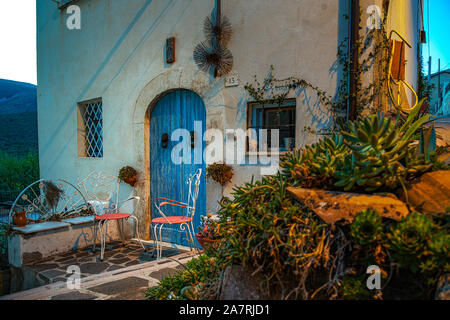 due sedie rosa e una porta bleu. Regione Abruzzo, Italia, Europa Foto Stock