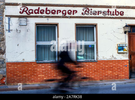 Bautzen, Germania. Xvii oct, 2019. Un uomo spinge la sua bici passato il vuoto ristorante 'Radeberg Bierstuben' nella città vecchia. Bautzen, alto sorabo Budy?in, è una grande città distretto nella parte orientale della Sassonia. La città si trova sul fiume Sprea e è la sede del distretto di Bautzen district, che è chiamato dopo di esso. Credito: Jens Büttner/dpa-Zentralbild/ZB/dpa/Alamy Live News Foto Stock