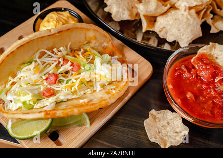 In casa Baja tacos di pesce con salsa di mango e trucioli. Miscelati cibo messicano: Guacamole, nachos, fajita, carne tacos. Vista dall'alto. Tex-mex cucina. Foto Stock