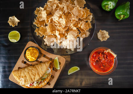 In casa Baja tacos di pesce con salsa di mango e trucioli. Miscelati cibo messicano: Guacamole, nachos, fajita, carne tacos. Vista dall'alto. Tex-mex cucina. Foto Stock