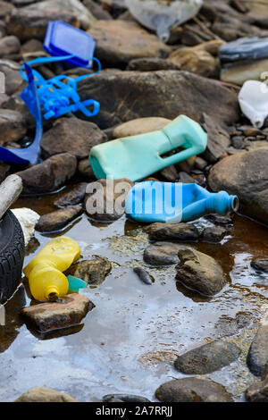 Immondizia di plastica e vecchio pneumatico in sporco oleoso acqua su Ocean Beach Foto Stock