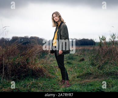 Ritratto di raffreddare donna in piedi su un campo Foto Stock