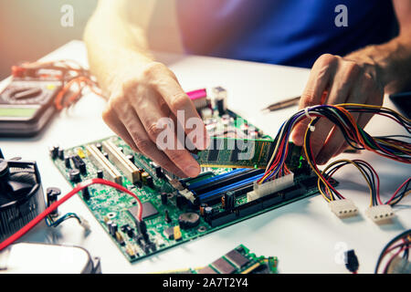 Assemblaggio del computer - tecnico installare ram modulo di memoria sulla scheda madre Foto Stock