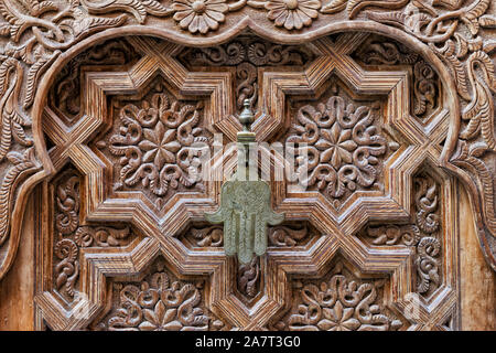 Ferro da stiro maniglia della porta del "Fatima" a mano su una tavola di legno, porta marocchino nel cuore della medina di Marrakech, Marocco. Foto Stock