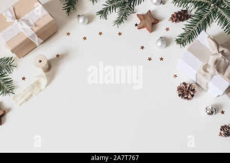 Festivo invernale composizione del telaio. Pigne, nastri di seta, Abete rami, regalo scatole, palle di Natale, baubles e stelle coriandoli isolare Foto Stock