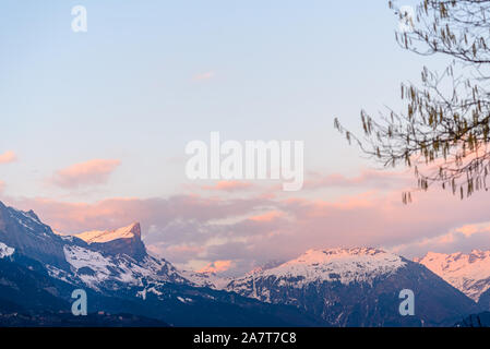 Tête du Colonney, tramonto e ultimi raggi di sole che cade su di big mountain top di gamma e nelle Alpi francesi, come visto da un villaggio di Domancy, Francia Foto Stock