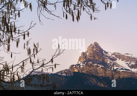 Tête du Colonney, tramonto e ultimi raggi di sole che cade su di big mountain top di gamma e nelle Alpi francesi, come visto da un villaggio di Domancy, Francia Foto Stock