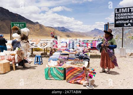 Donna Peruviana locale di vendita di tessuti e tessuti realizzati da alpaca ald di lana di lama Foto Stock