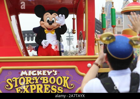 --FILE--animatore vestito in un topolino costume interagisce con un visitatore durante una parata nella Shanghai Disneyland a Shanghai la Disney ri Foto Stock